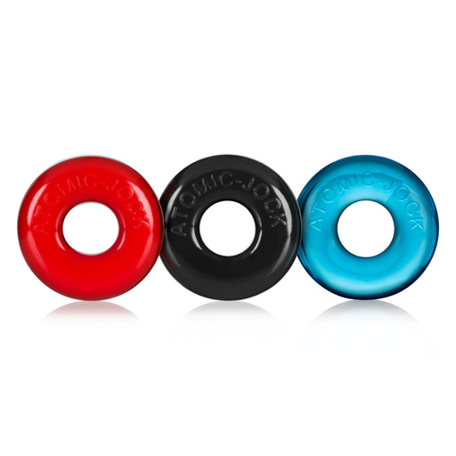 Tres anillos para pene de color rojo, negro y azul puesto de lado a lado uno del otro, de pie sobre fond blanco