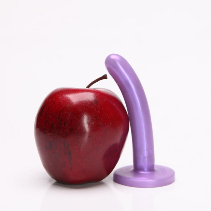 Dildo anal silk small tantus al lado de una manzana rojo