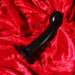 Dildo anal para prostata Tantus Sport en situación sobre un fondo de tela rojo