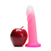 Dildo anal estimulador de prostata de doble textura azul de modelo Flurry rosado pink al lado de una manzana 